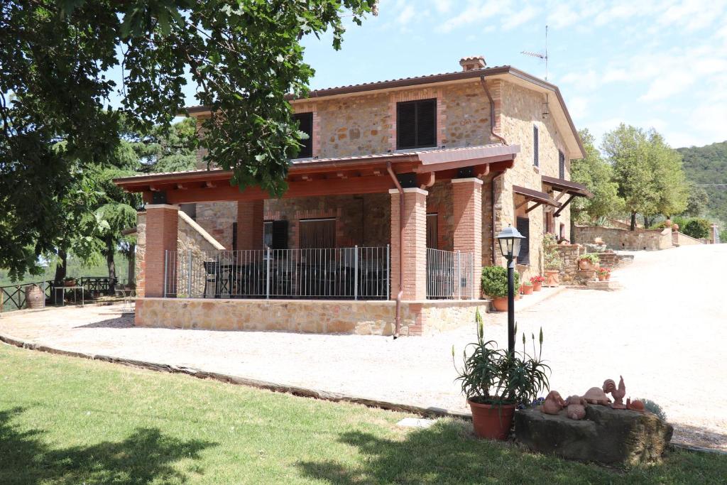 a large brick house with a porch at La Corte dei Banchetti in Gualdo Cattaneo