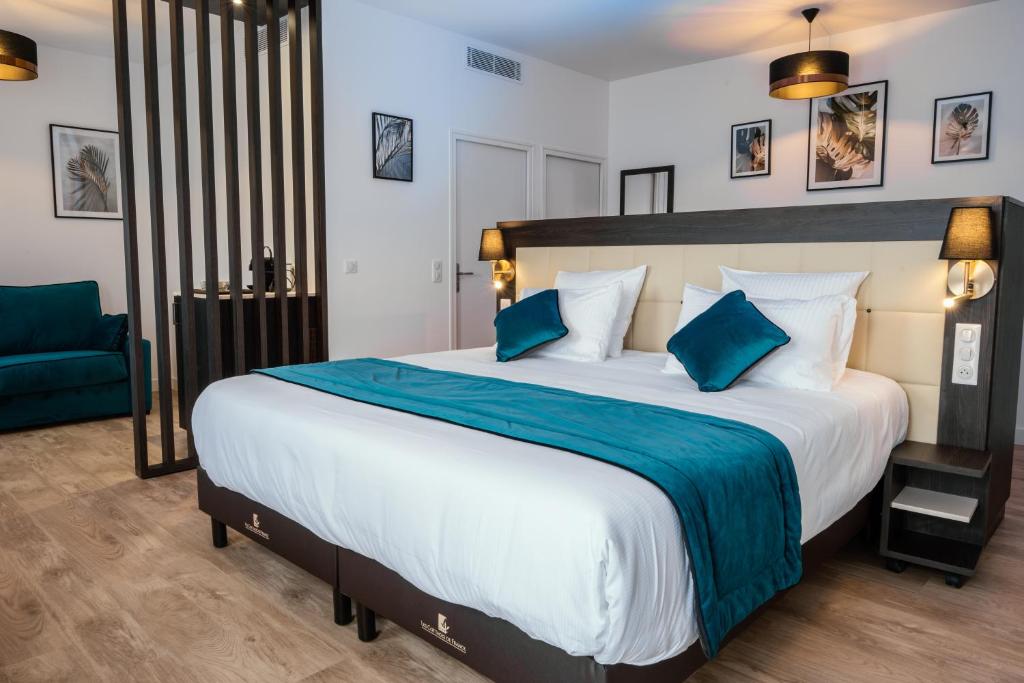 um quarto com uma cama grande e uma cadeira azul em Cottages de France CDG em Saint-Mard