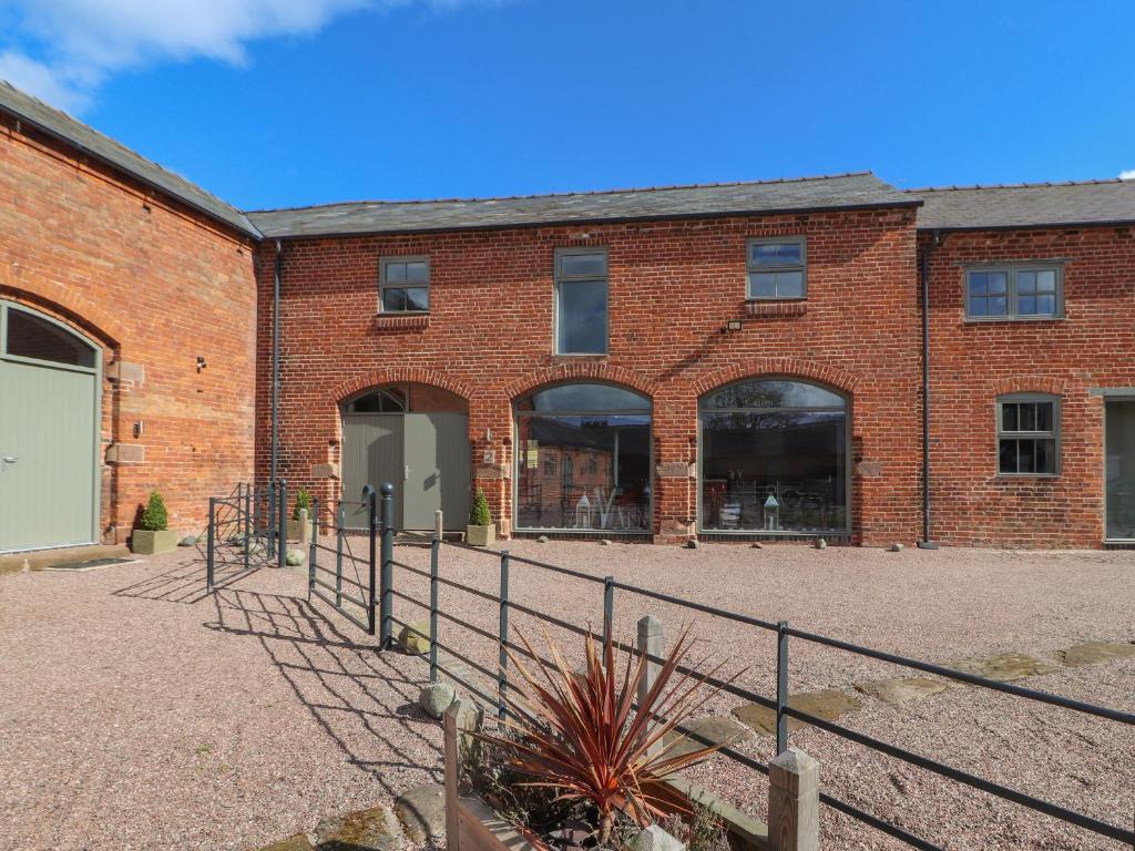 un edificio de ladrillo con una puerta delante de él en The Cart House en Whitchurch