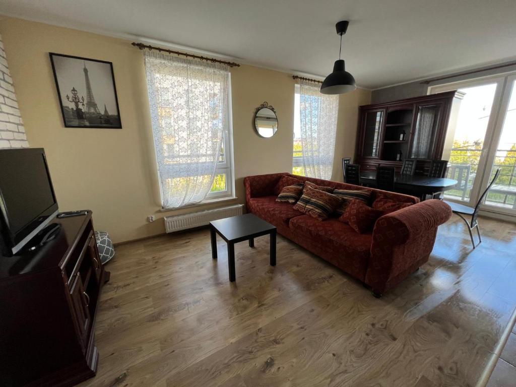 a living room with a couch and a tv at Cozy apartment close to Gdansk & Airport in Gdańsk
