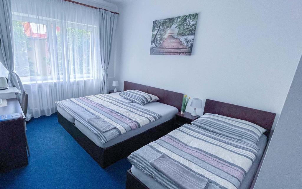 a hotel room with two beds and a window at Minihotel Vitex in Prague