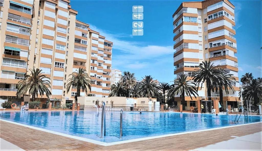 a large swimming pool in front of two tall buildings at Bonito Apartamento en Algarrobo-Costa in Algarrobo-Costa