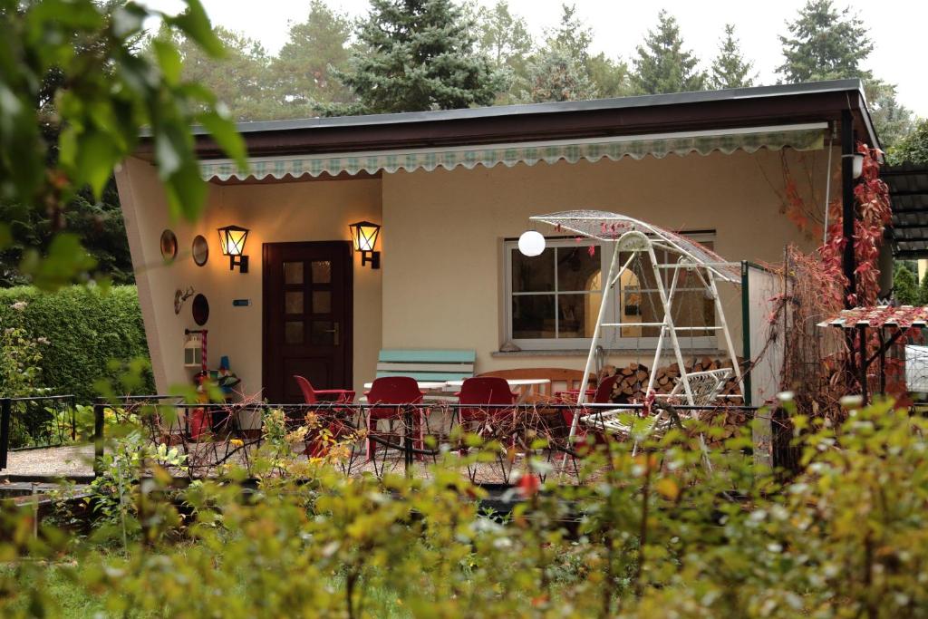 een klein huis met een tafel en stoelen in een tuin bij The Eastbank 16 in Pinnow