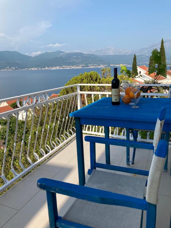 - une table bleue avec une bouteille de vin sur un balcon dans l'établissement Seaview Apartments, à Krasići