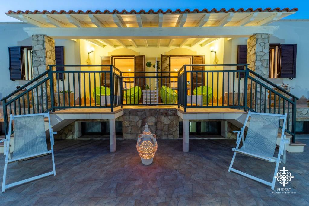 een veranda aan de voorzijde van een huis met 2 stoelen bij Borgo Marino Beach Residence in Lampedusa