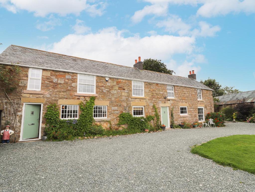 an old stone house with a green door at Cae Adar Farm in Wrexham