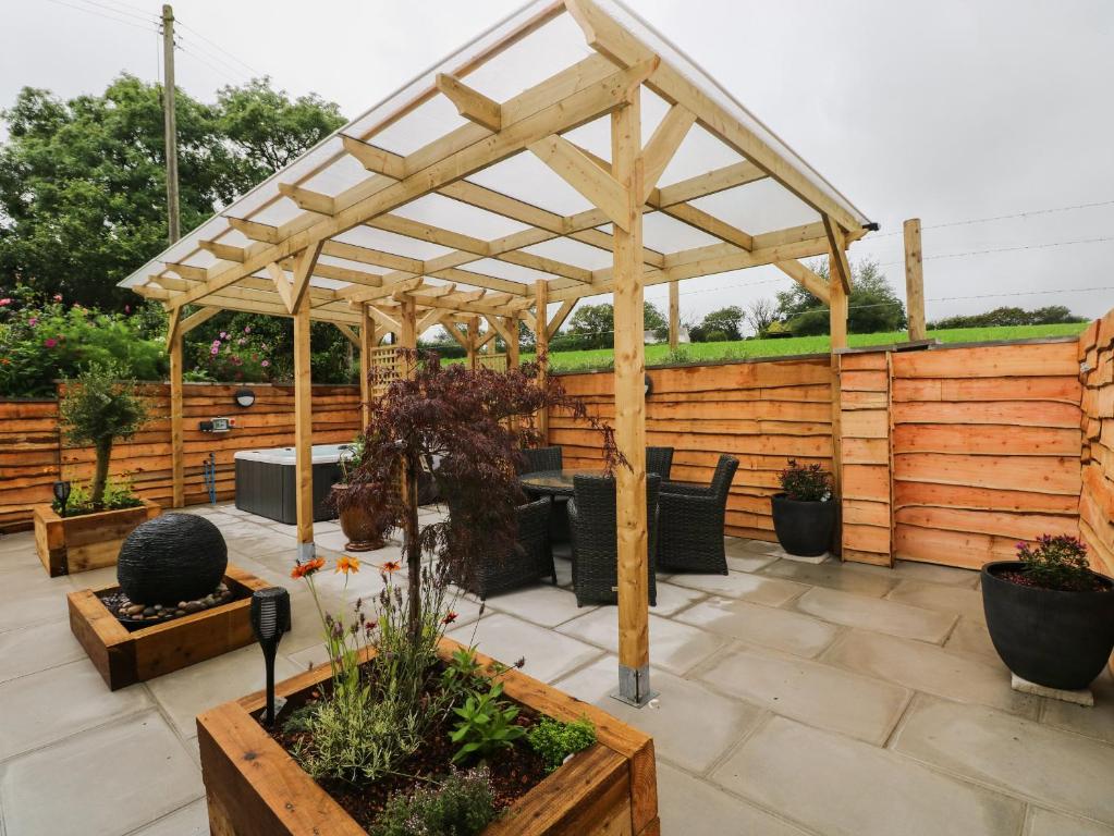 eine hölzerne Pergola auf einer Terrasse mit Pflanzen in der Unterkunft Brynawel in Carmarthen