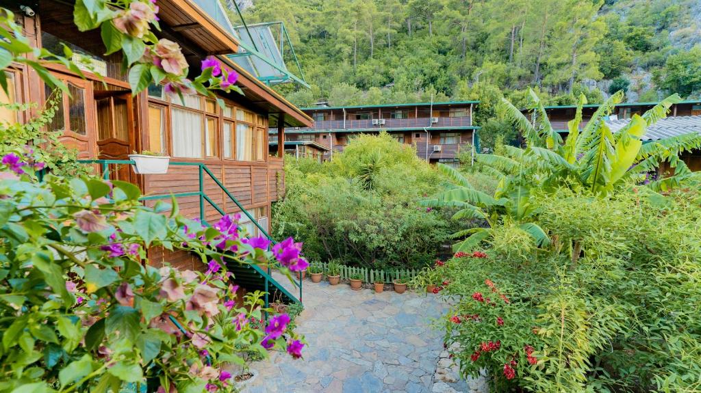 an outdoor garden with flowers and a building at Turkmen Tree Houses in Olympos