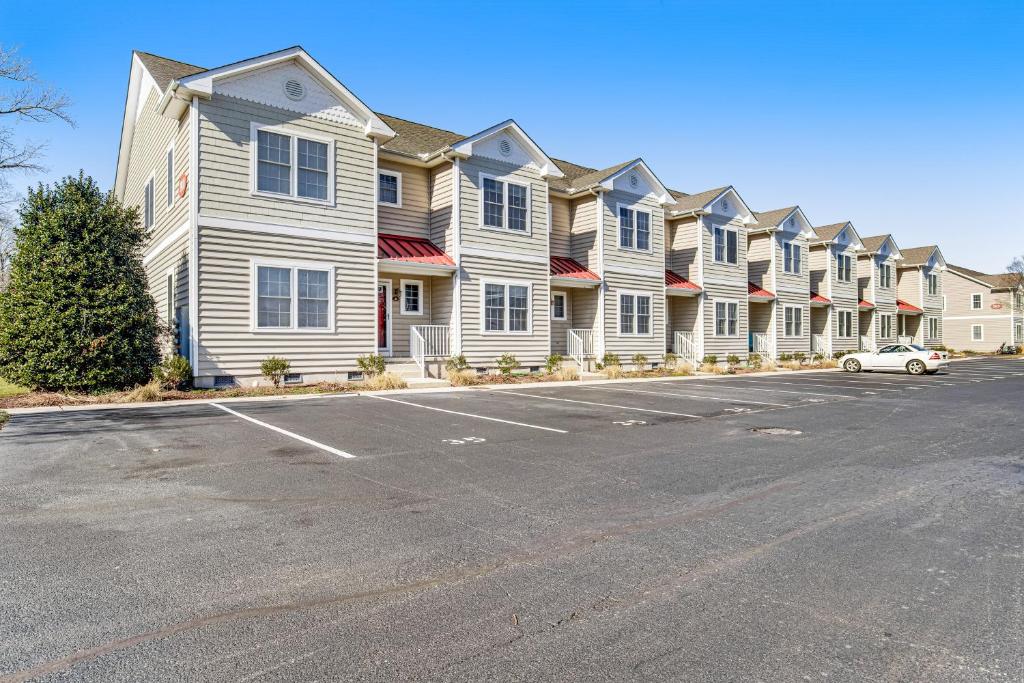 a row of houses with cars parked in a parking lot at Oyster Bay Villas --- 20411 Jeb Dr Unit #37 in Rehoboth Beach