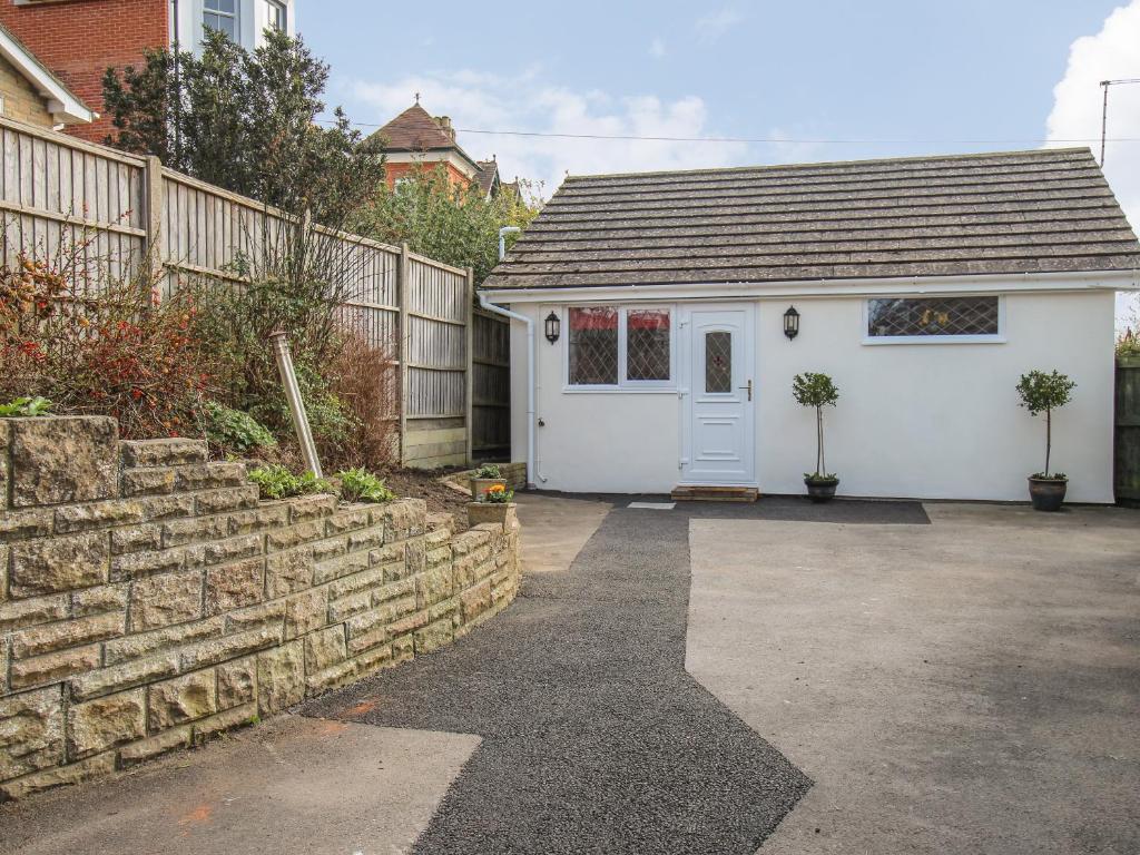 a small house with a white door and a fence at Roundham Cottage in West Bay