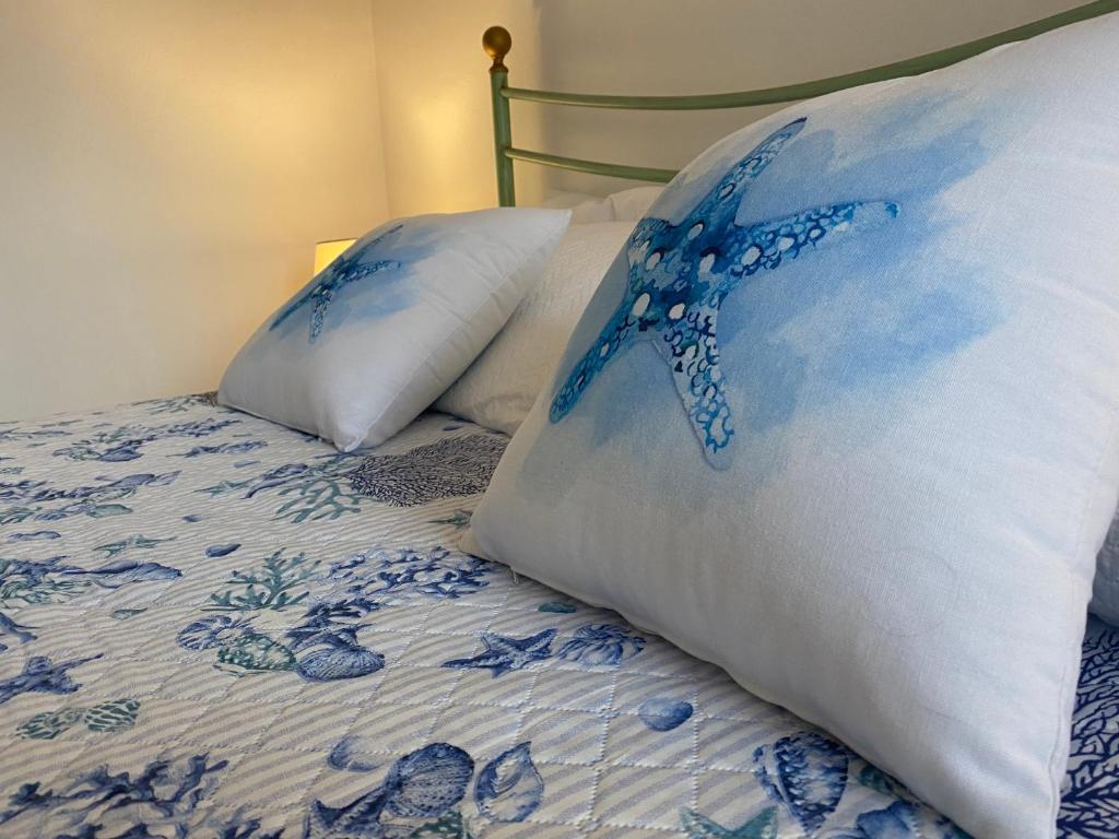 een blauw en wit bed met 2 kussens erop bij Vento di Mare in Muravera