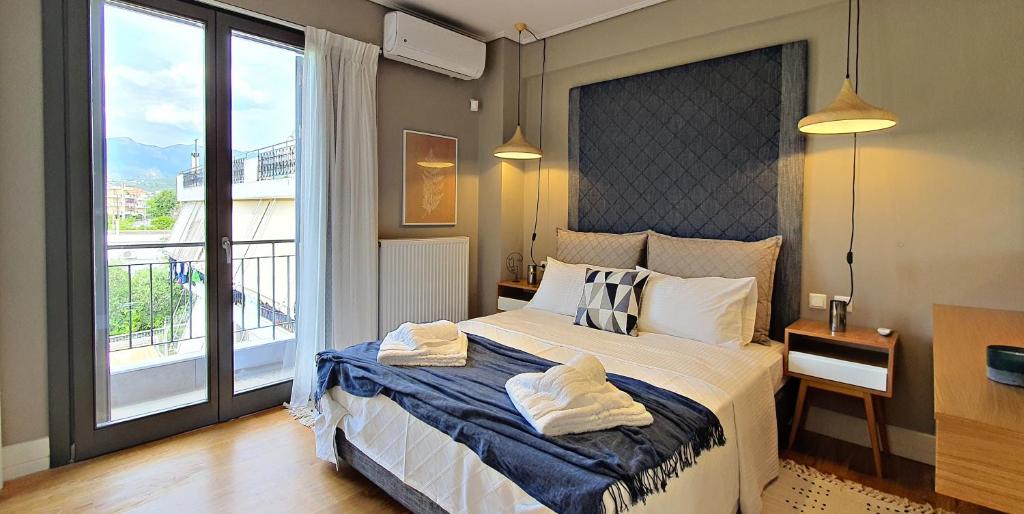 - une chambre avec un grand lit et une grande fenêtre dans l'établissement Malamas Apartment, à Kalamata