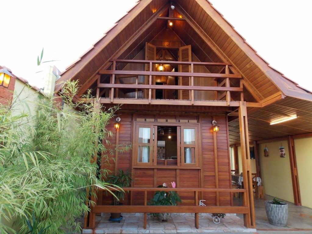 Casa de madera grande con balcón grande en Chalé Paraíso com piscina em Brotas SP, en Brotas