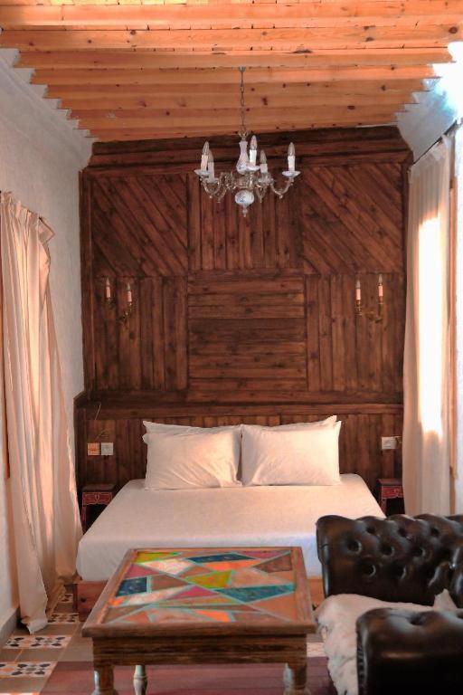 a bedroom with a bed with a wooden head board at RIAD LA SANTA in Chefchaouen