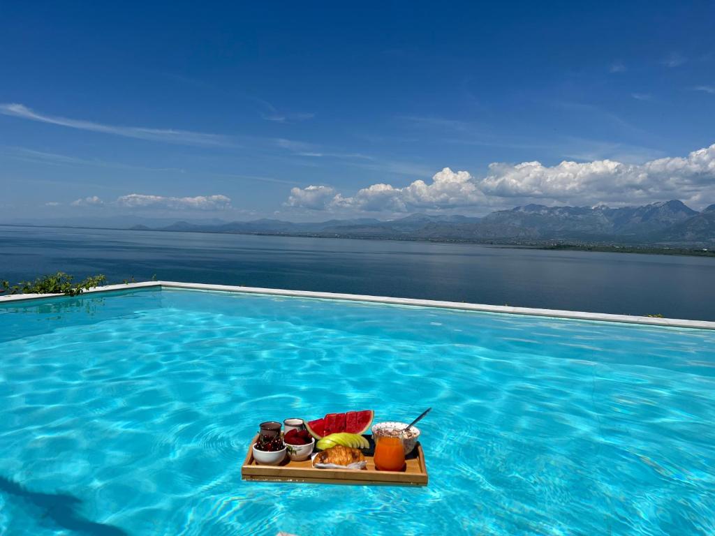 a swimming pool with a tray of food in the water at Lake Breeze Villa with a Pool & Magnificent Views in Shirokë