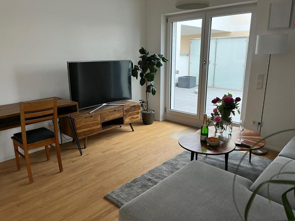 TV a/nebo společenská místnost v ubytování Traumhafte neue Dachterrassenwohnung am Soyener See