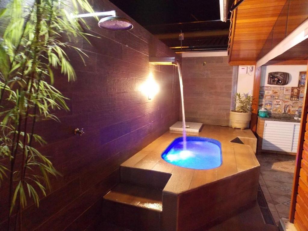 a bathtub with a blue pool in a room at Chalé aconchegante em Brotas SP in Brotas