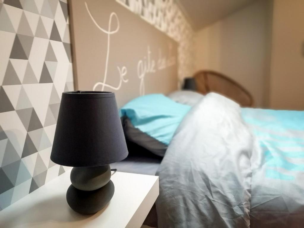 eine Lampe auf einem Tisch neben einem Bett in der Unterkunft Gîte des lacs in Meussia