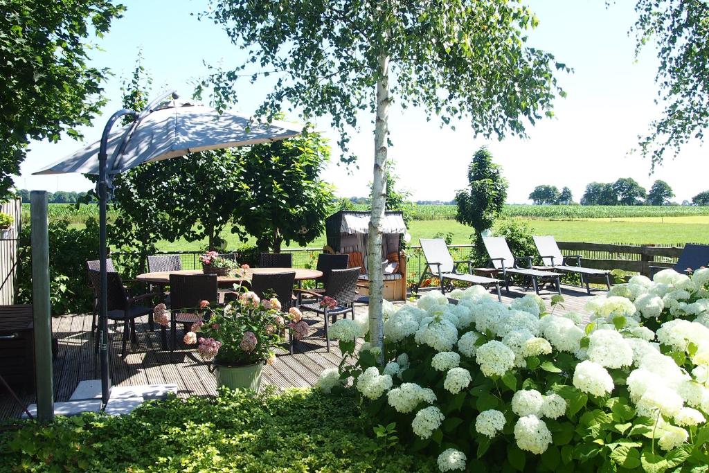 um jardim com mesa, cadeiras e flores brancas em Natures-Rest Wielen em Wielen