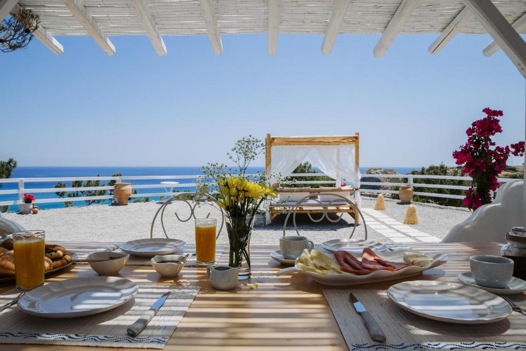 a table with food and a view of the beach at Endless Horizon At Stegna in Archangelos