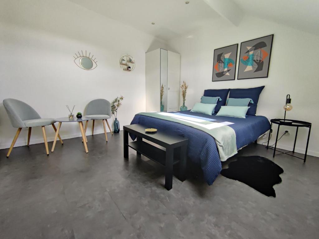 a bedroom with a blue bed and a table and chairs at Studio Hypercentre - Quartier Gare in Valenciennes