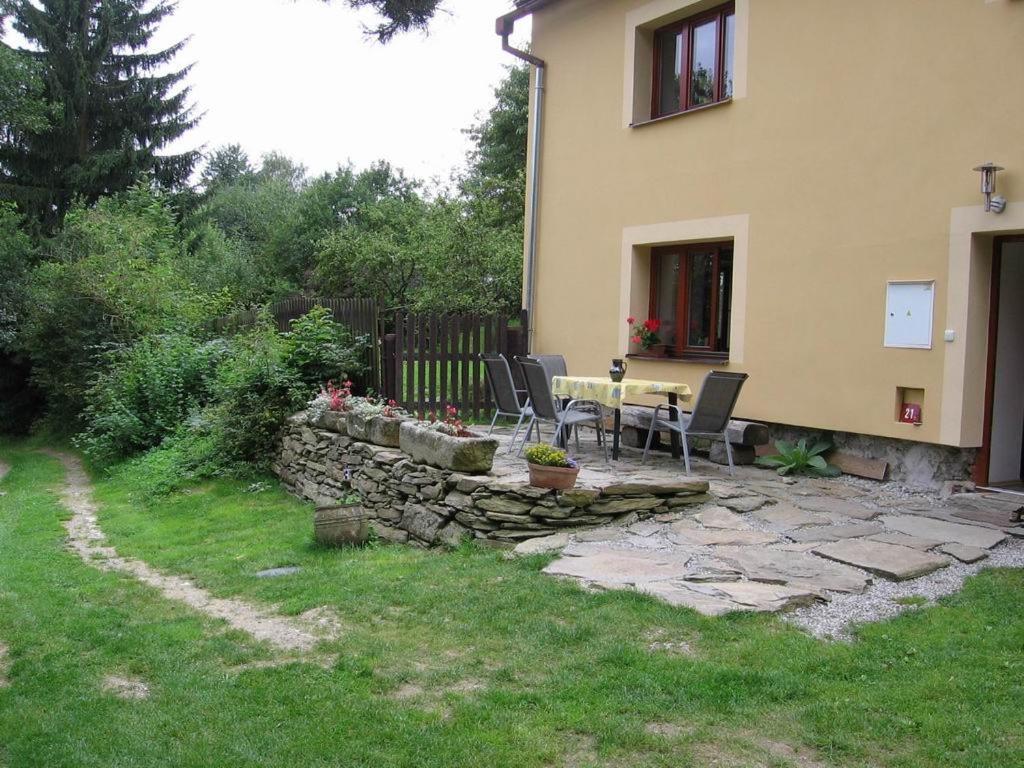 eine Terrasse mit einem Tisch und Stühlen neben einem Haus in der Unterkunft Chalupa U Effoucha in Lipno nad Vltavou