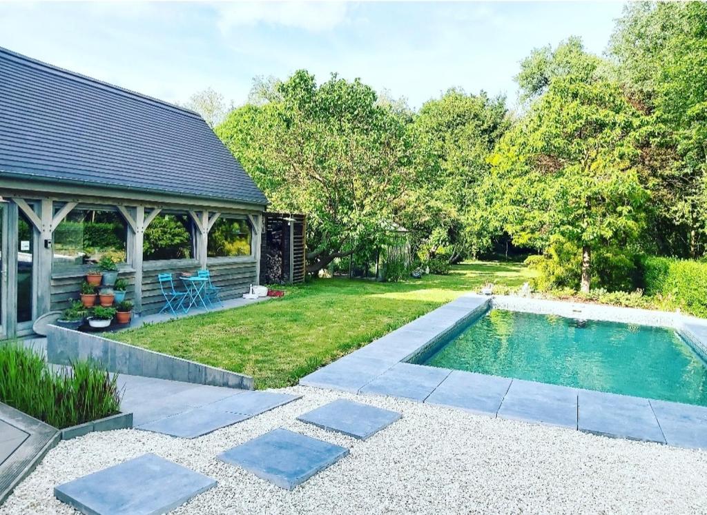 a backyard with a swimming pool and a house at De linderd in Aalst