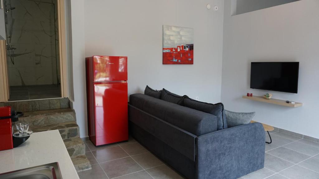 a living room with a couch and a red refrigerator at Avli Luxury Apartment in Ierissos