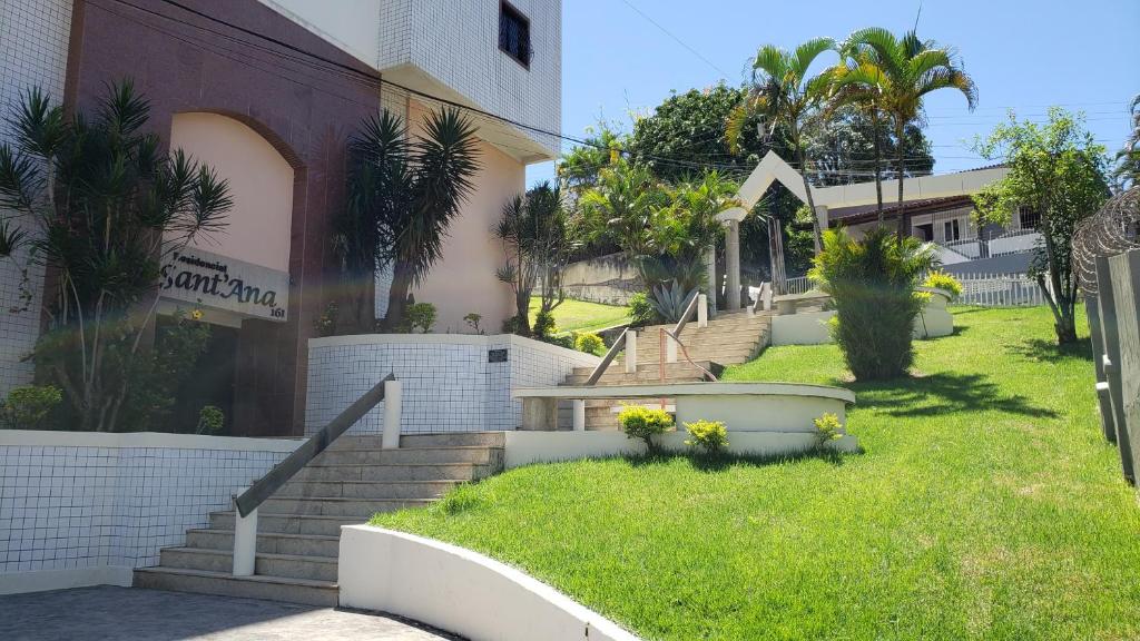 a building with stairs next to a grass yard at Apartamento Centro de Guarapari - Próximo a Praia in Guarapari