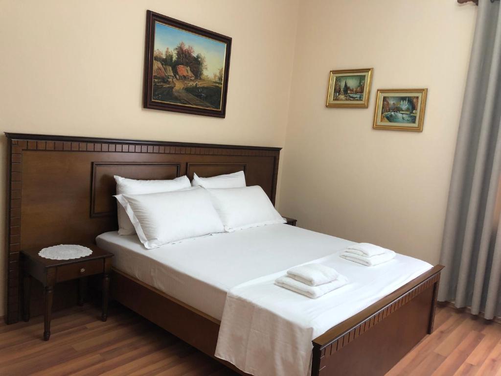 - une chambre avec un lit doté de draps et d'oreillers blancs dans l'établissement Villa Garden, à Berat
