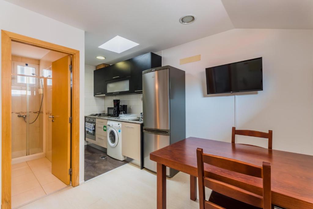 a kitchen with a dining room table and a refrigerator at Historic Center 3 in Coimbra