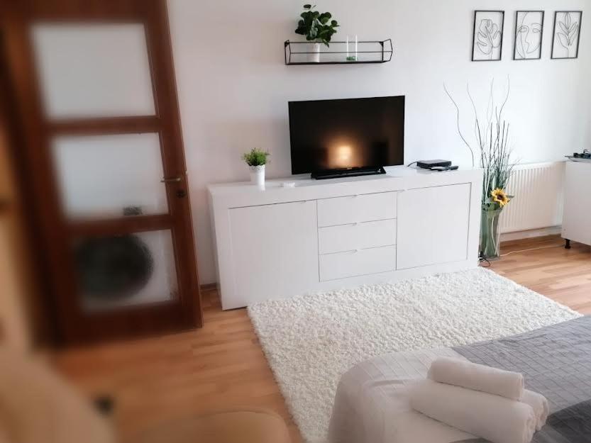 un salon avec une télévision sur une commode blanche dans l'établissement Nexus Studio Deluxe, à Miercurea-Ciuc