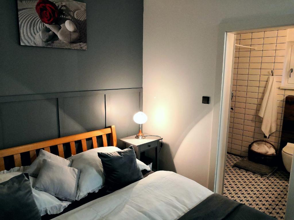 sypialnia z łóżkiem z białą pościelą i poduszkami w obiekcie Apartmány RŮŽIČKA w mieście Mikulov