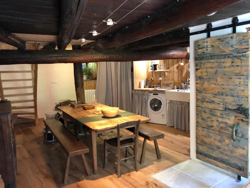kuchnia z drewnianym stołem z krzesłami i kuchenką w obiekcie Mon Roc - Maison de montagne atypique avec vue w mieście La Grave
