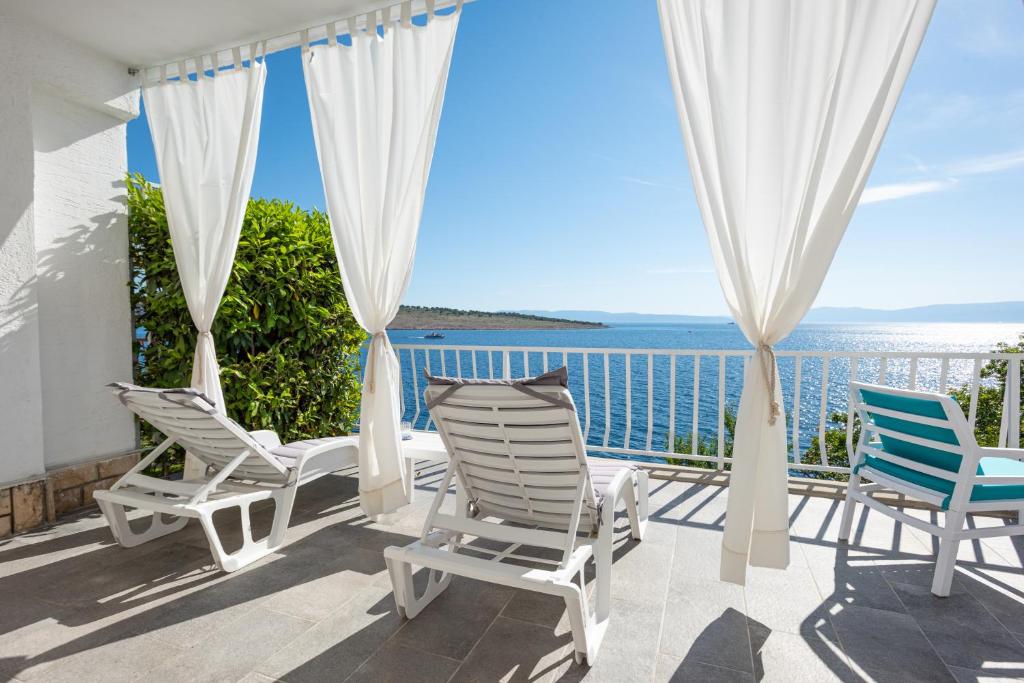 Un balcón con sillas y vistas al océano. en Apartments Viky, en Kraljevica