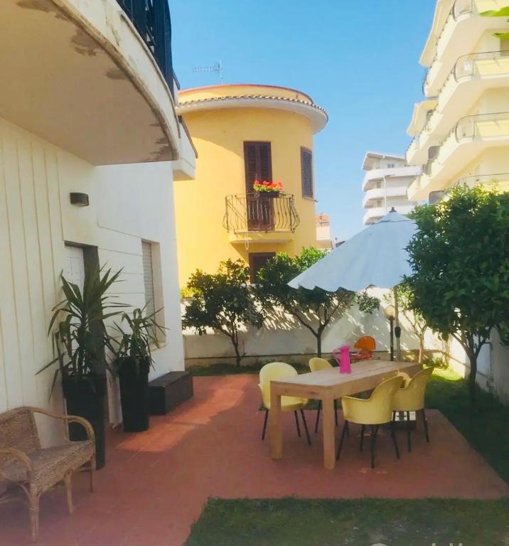 a patio with a table and chairs and an umbrella at Sinilu a mare in Montesilvano