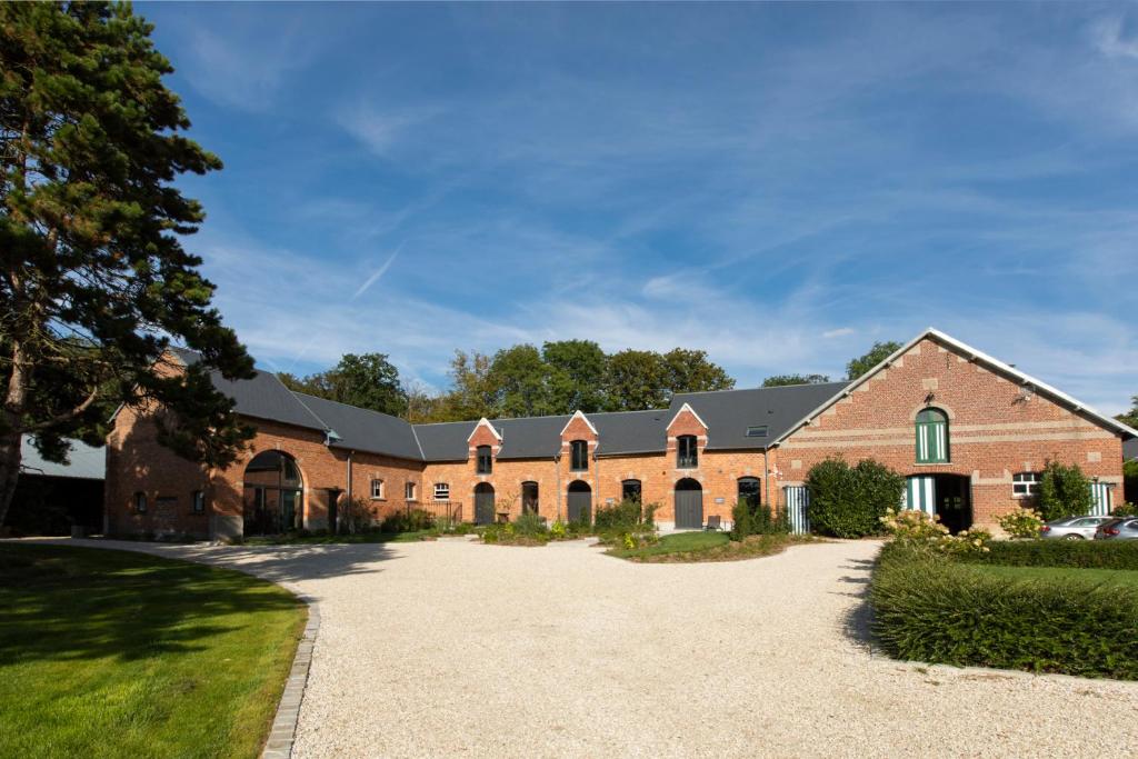 a large brick building with a driveway at Aux Petits Lapins de Sorval, sauna privé, fitness in Selvigny