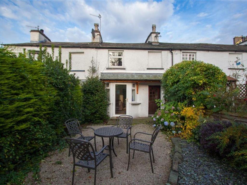 a table and chairs in front of a house at Rustic Cottage in Windermere