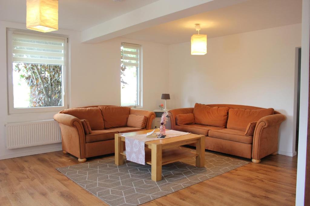 a living room with two couches and a coffee table at Viel Platz und ungestört für sich in Diepenau