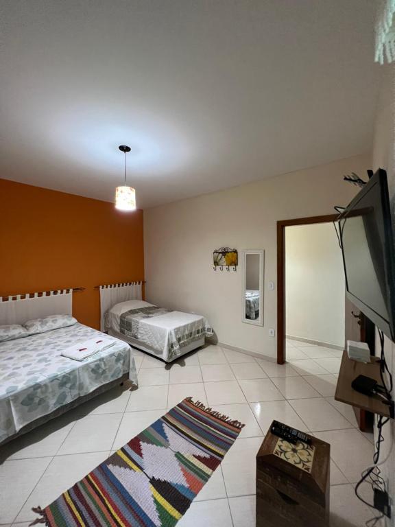 a bedroom with two beds and a flat screen tv at Apartamento Elite em Cunha in Cunha
