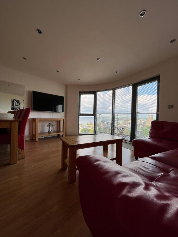 a living room with a couch and a table at Newquay Horizons in Newquay