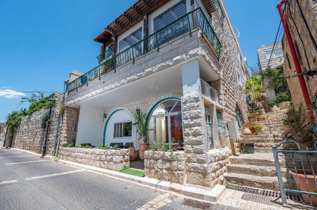 uma casa de pedra com uma varanda numa rua em Boutique Suites - Prime Location Old City em Safed
