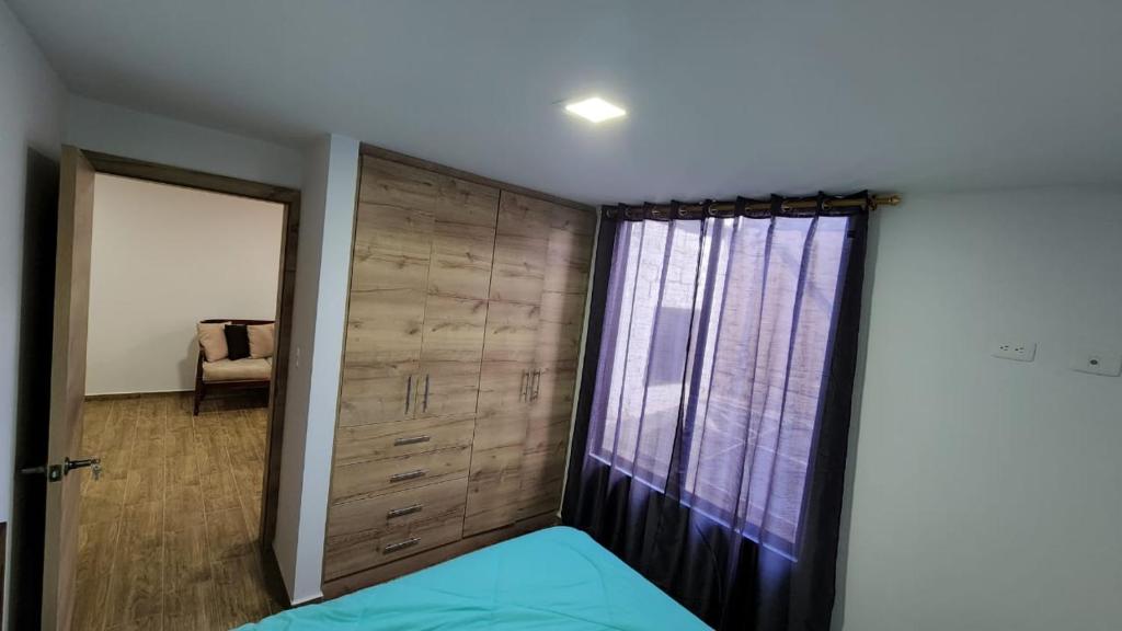 a bedroom with a sliding door and a window at Departamento completo de dos habitaciones la Estación del Tren 3 in Riobamba