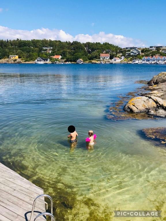 two children swimming in a body of water at Hytte i skjærgården in Kristiansand