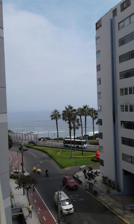 uma vista para uma rua a partir de um edifício com o oceano em NEREO rooms em Lima