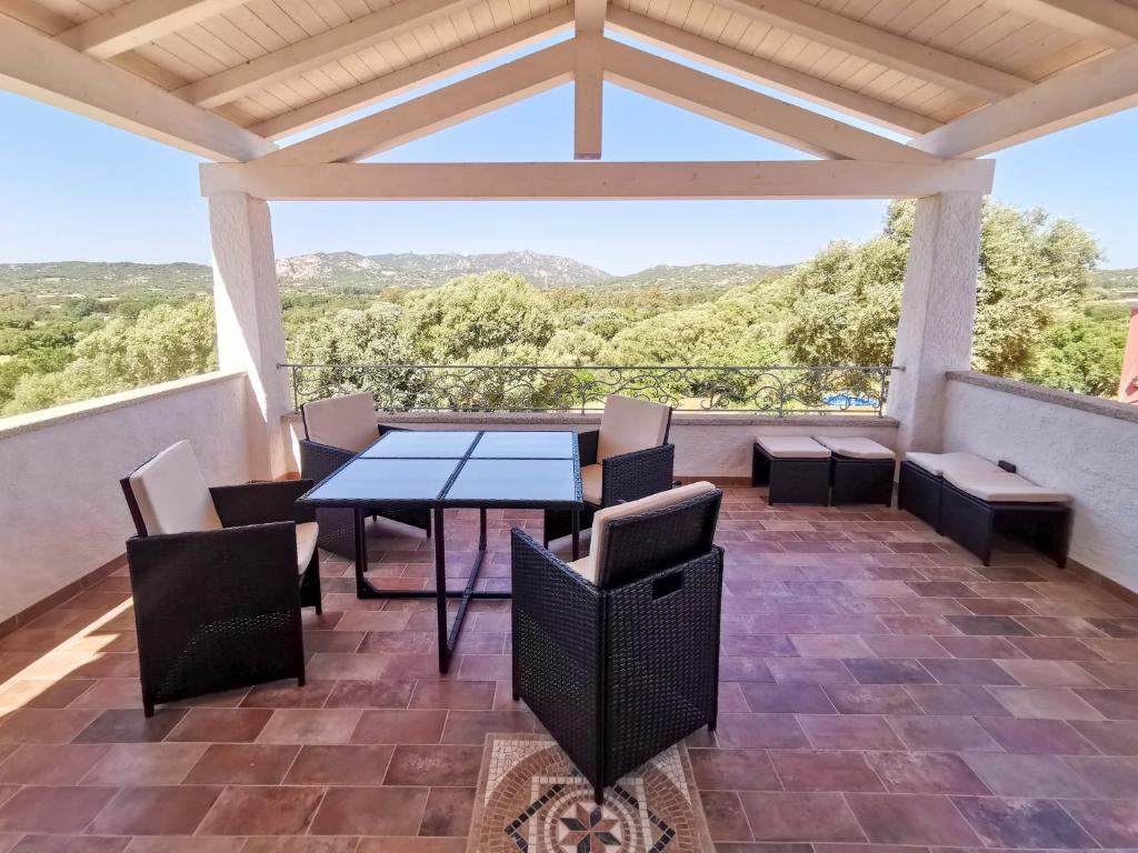 a patio with a table and chairs on a balcony at Casa Aurora in San Pantaleo
