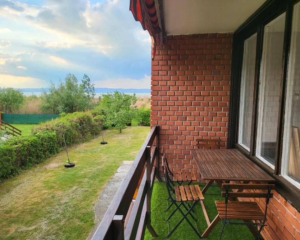 a balcony with two chairs and a table and a window at Balatonic apartman in Zamárdi