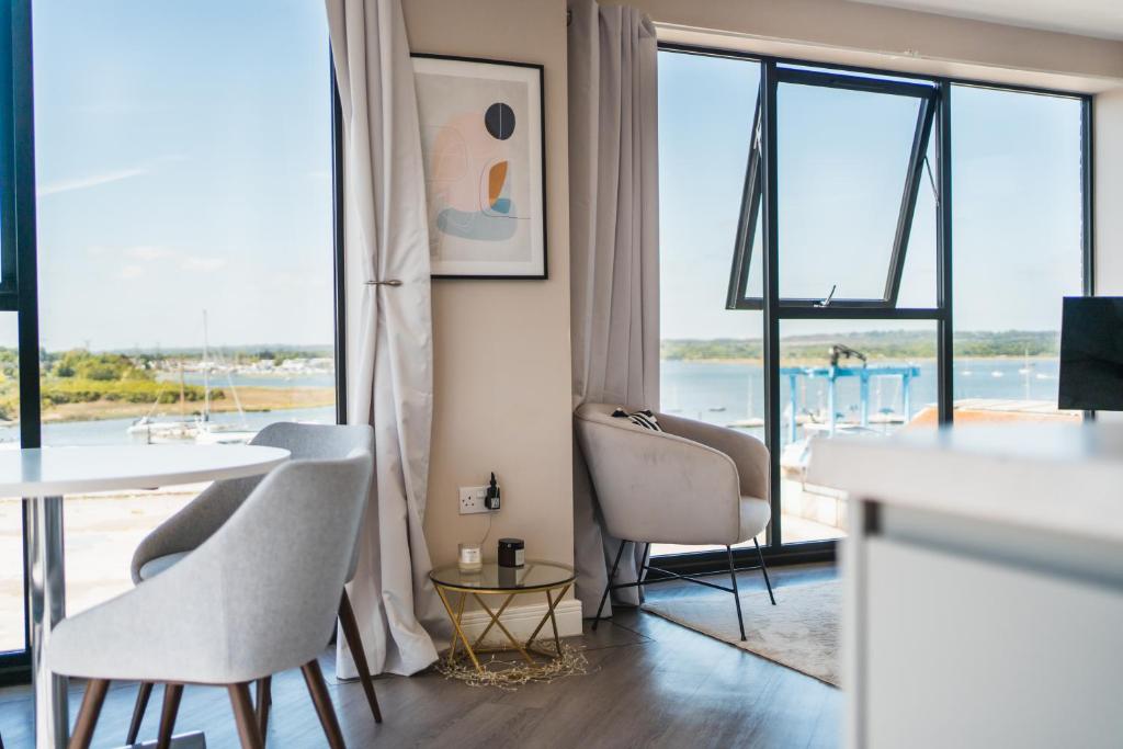 a living room with a table and chairs and a large window at Penthouse - Harbour Views in Poole