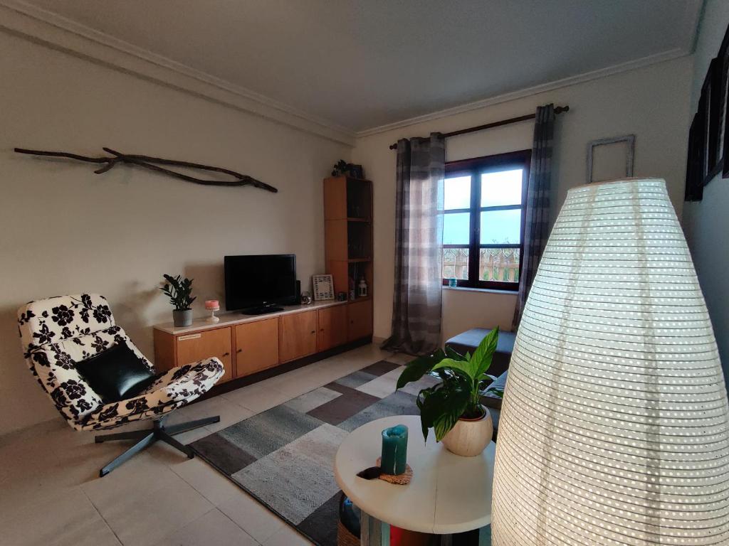 a living room with a chair and a table at Beach Front Apartment in Gafanha da Nazaré