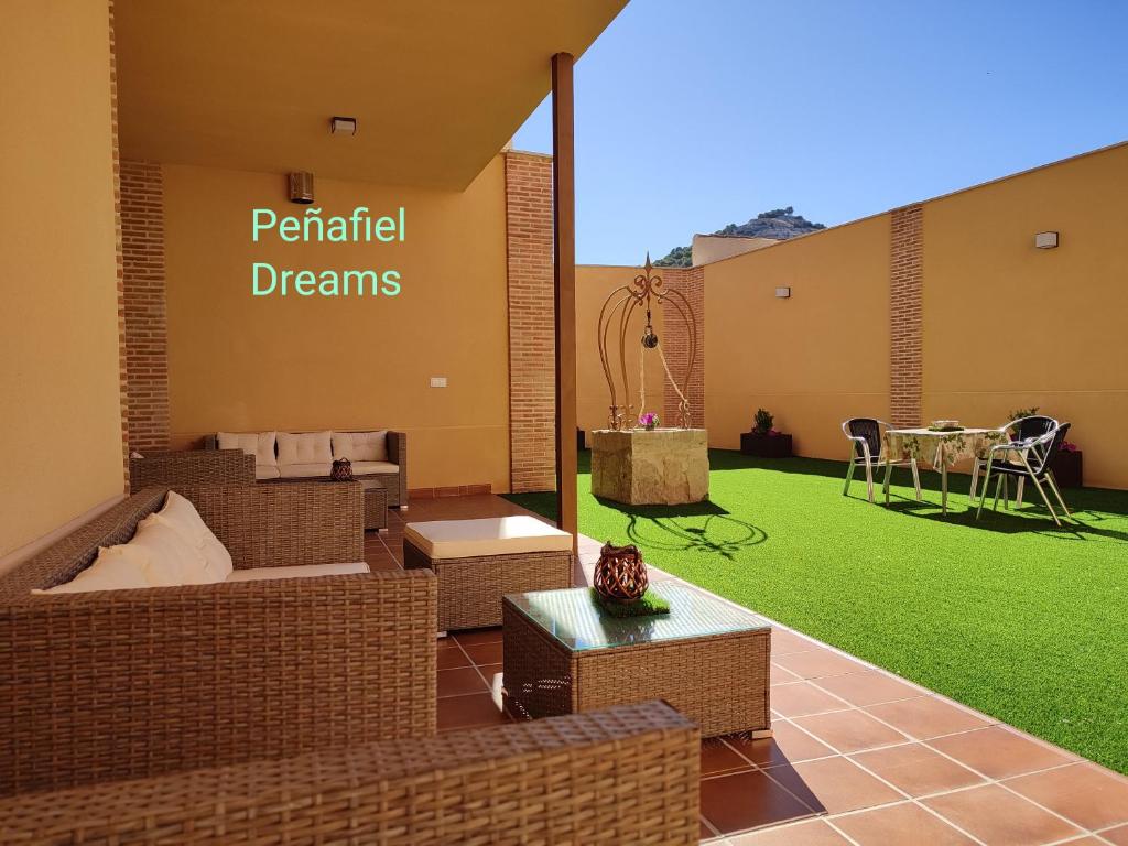 een patio met een groen gazon en een tafel bij PEÑAFIEL DREAMS CON JACUZZI 4 PERSONAS in Peñafiel
